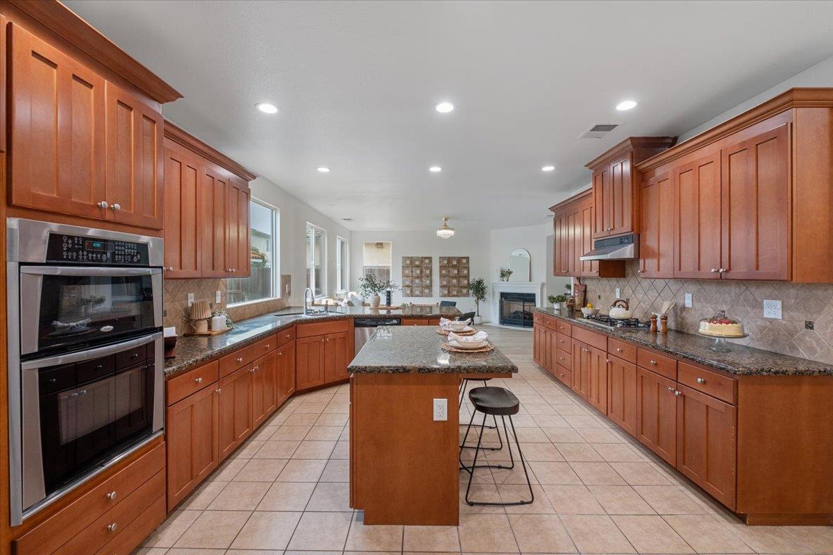 2413 Ventana View Way Modesto, CA 95355 - Photo 19 of 51 a large kitchen with stainless steel appliances granite countertop a stove top oven a sink dishwasher and cabinets