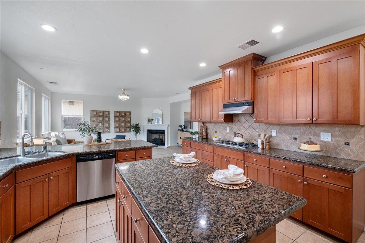 2413 Ventana View Way Modesto, CA 95355 - Photo 20 of 51 a kitchen with granite countertop stainless steel appliances a sink stove top oven and cabinets