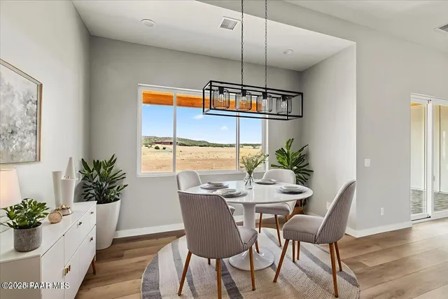 a dining room with furniture potted plants and wooden floor
