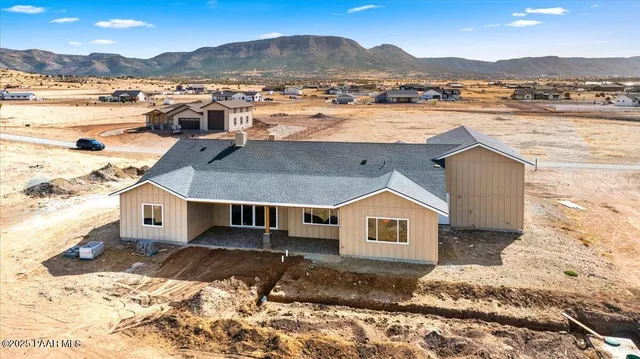 a front view of a house with a yard and mountain view