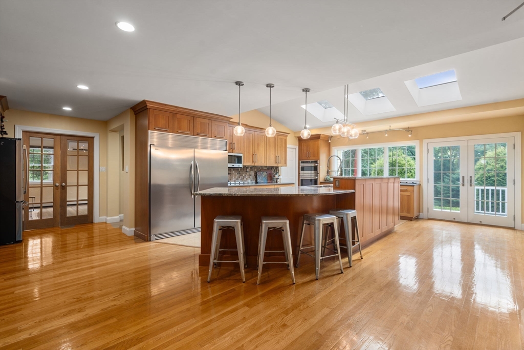 24 Russett Hill Road Sherborn, MA 01770 - Photo 11 of 39 a dining hall with stainless steel appliances granite countertop a sink dishwasher and a dining table with wooden floor
