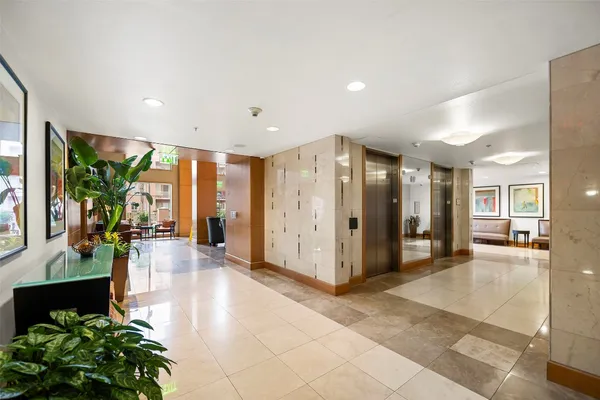 a lobby with furniture and potted plants