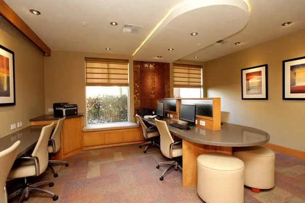 a view of a workspace with furniture and a window