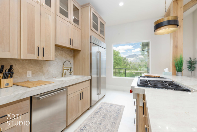 1188 South Old Trappers Loop Road Huntsville, UT 84317 - Photo 27 of 92 Modern kitchen with light wood cabinetry, stainless steel appliances, a large window showcasing mountain scenery, a built-in gas range, and light-toned countertops