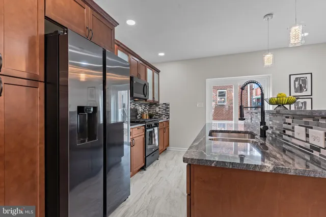 a kitchen with stainless steel appliances granite countertop a refrigerator and a stove