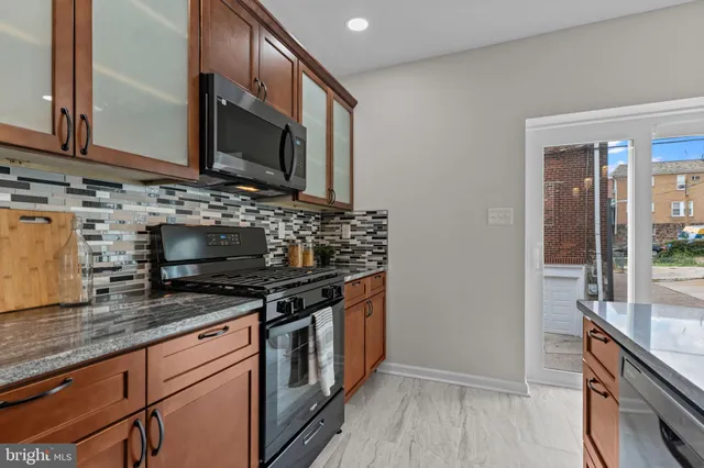 a kitchen with stainless steel appliances granite countertop a stove and a microwave
