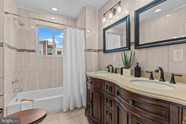 a bathroom with a tub a sink and mirror