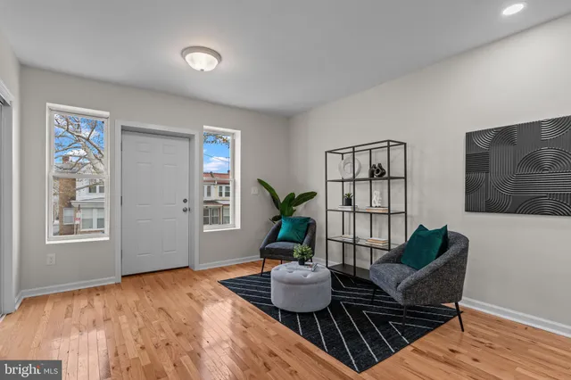 a living room with furniture wooden floor and wall paintings