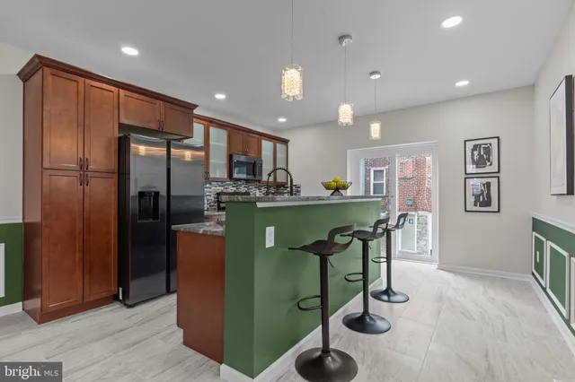 a kitchen with refrigerator and chairs