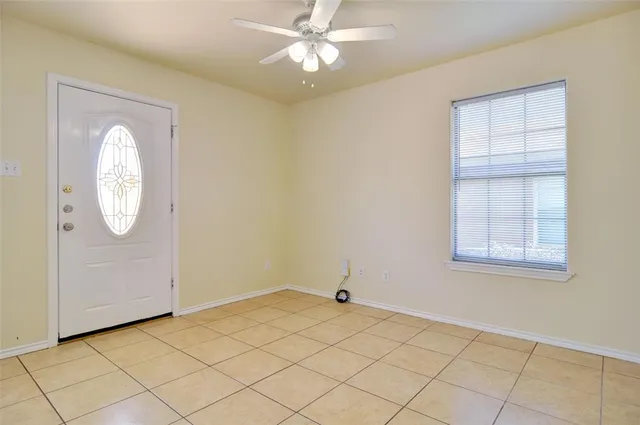 a view of a room with a chandelier fan and windows