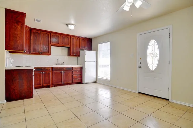 a kitchen with granite countertop a stove a refrigerator and a sink