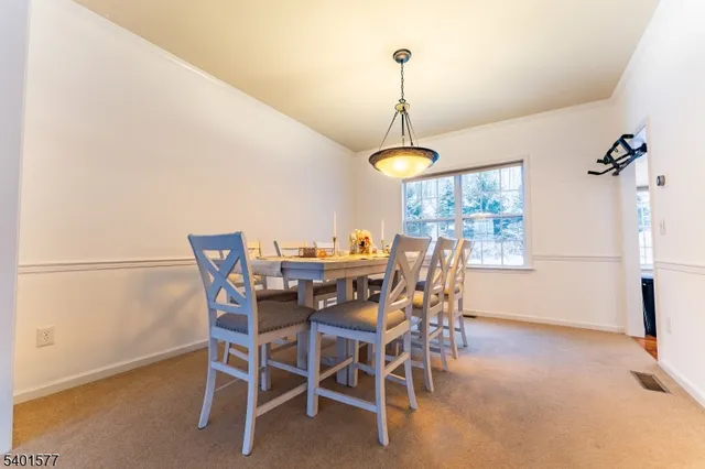 a view of a dining room and a livingroom with furniture wooden floor a chandelier
