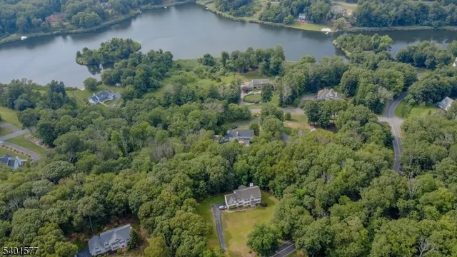 an aerial view of a house with a yard and lake view