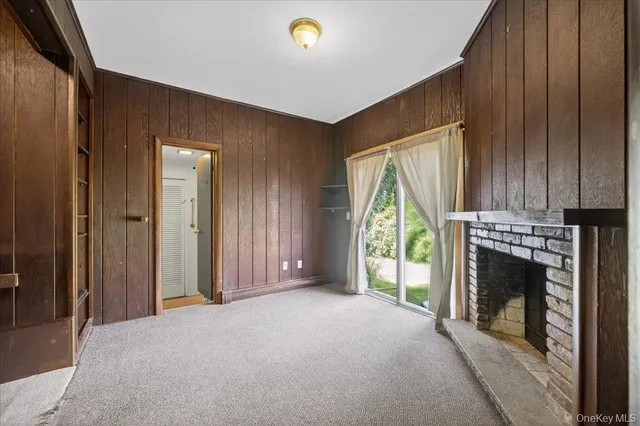 a view of an empty room with a fireplace and a window