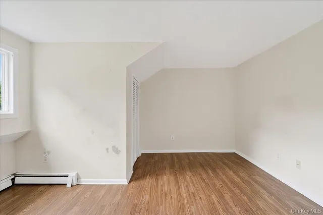 a view of a room with wooden floor and window