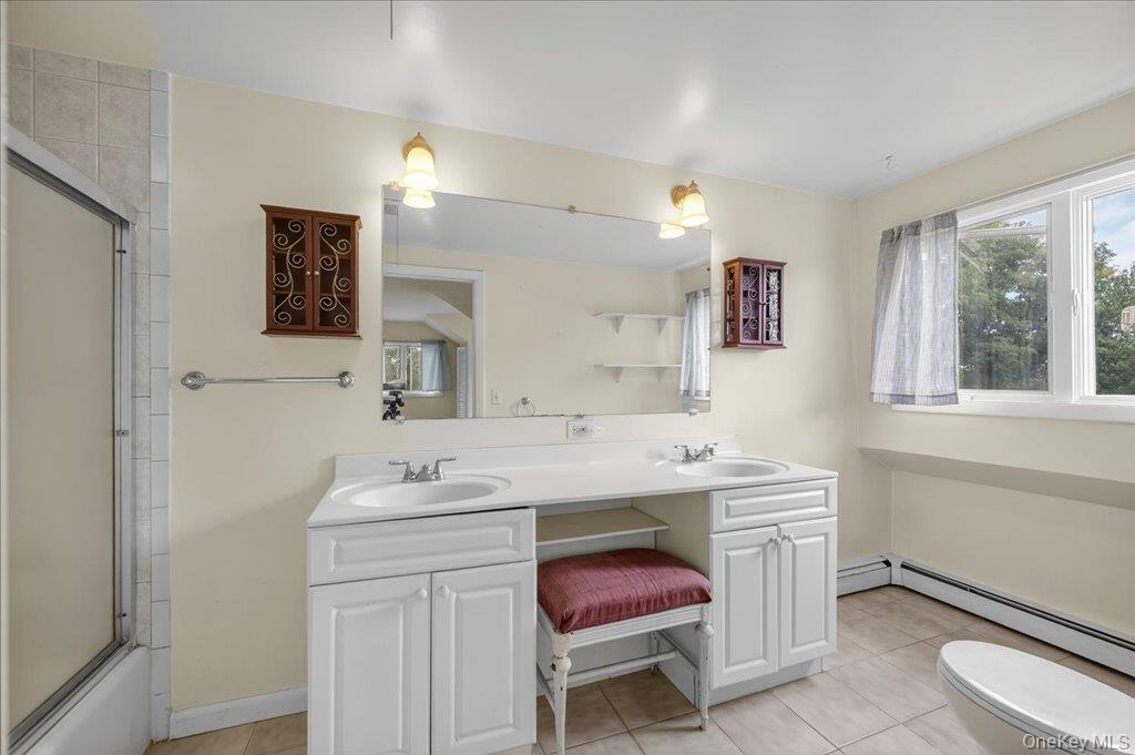 14 Moss Hill Road Holmes, NY 12531 - Photo 40 of 50 a bathroom with a sink a toilet a mirror and a window