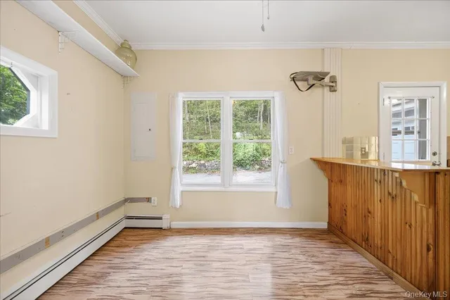 a view of a hallway with wooden floor and a living room