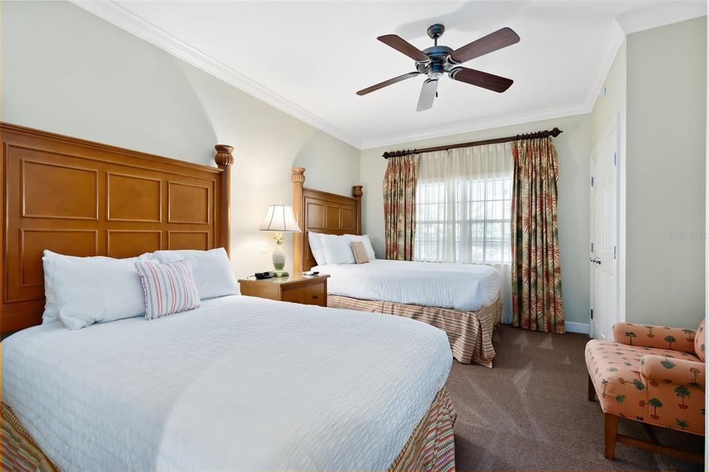1360 Centre Ct Ridge Drive, Unit 201 Reunion, FL 34747 - Photo 21 of 29 a bedroom with two beds and a chandelier