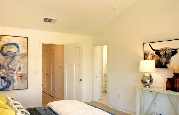 a bedroom with a bed and a painting on the wall