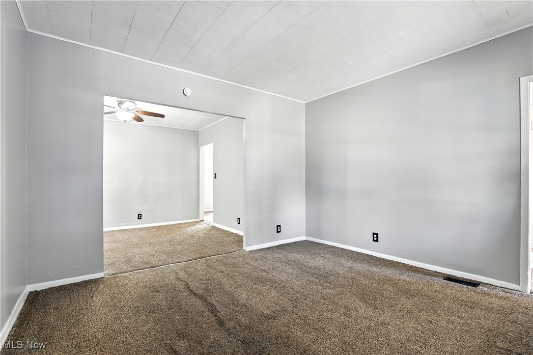 1774 Urbana Road Cleveland, OH 44112 - Photo 5 of 41 Carpeted spare room with a ceiling fan and baseboards