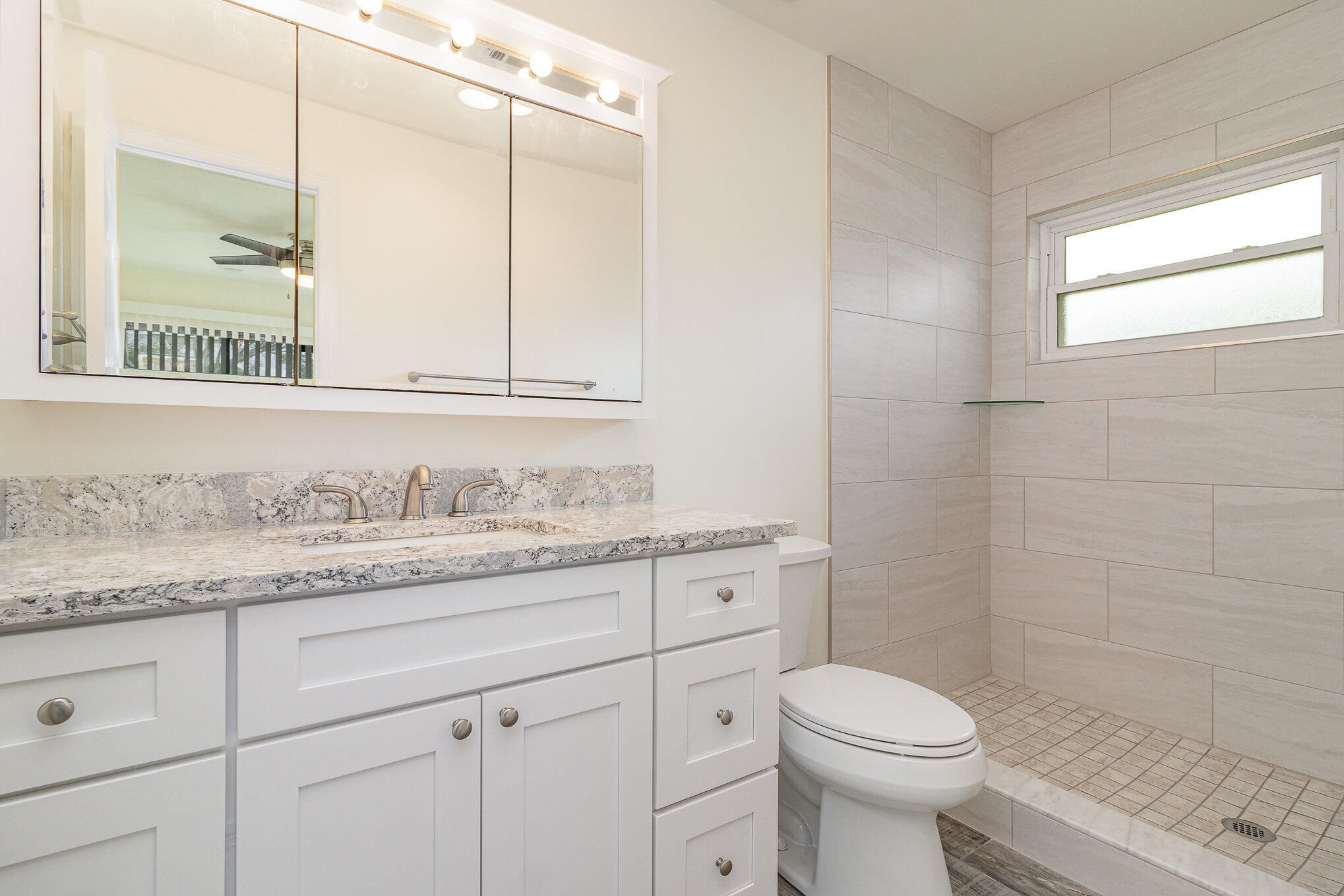 446 Timberlake Drive Melbourne, FL 32940 - Photo 11 of 20 a bathroom with a granite countertop toilet sink and mirror