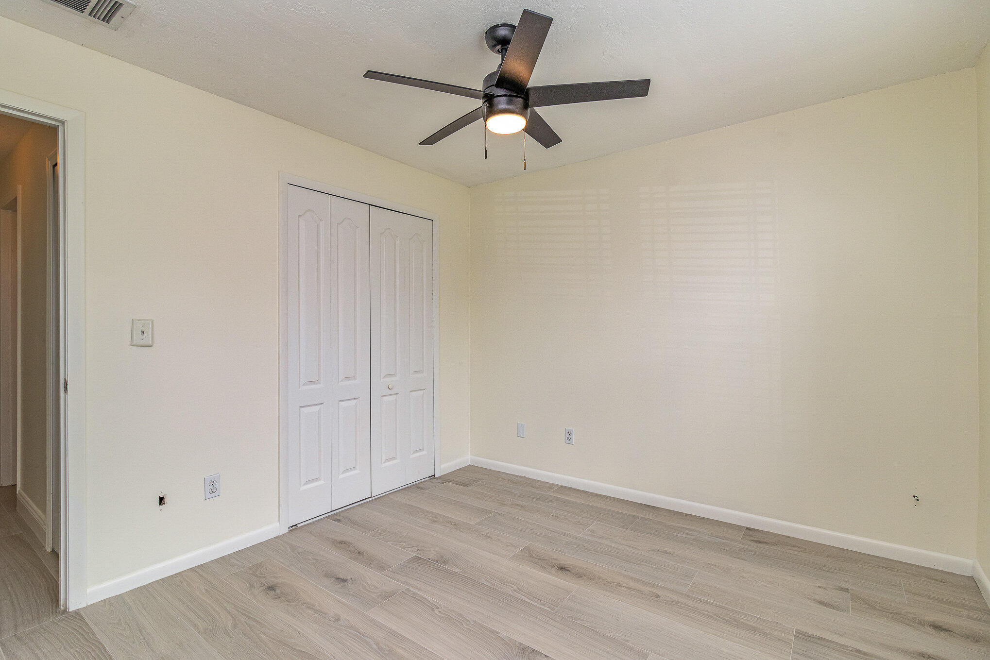 446 Timberlake Drive Melbourne, FL 32940 - Photo 15 of 20 a view of a room with wooden floor and a ceiling fan