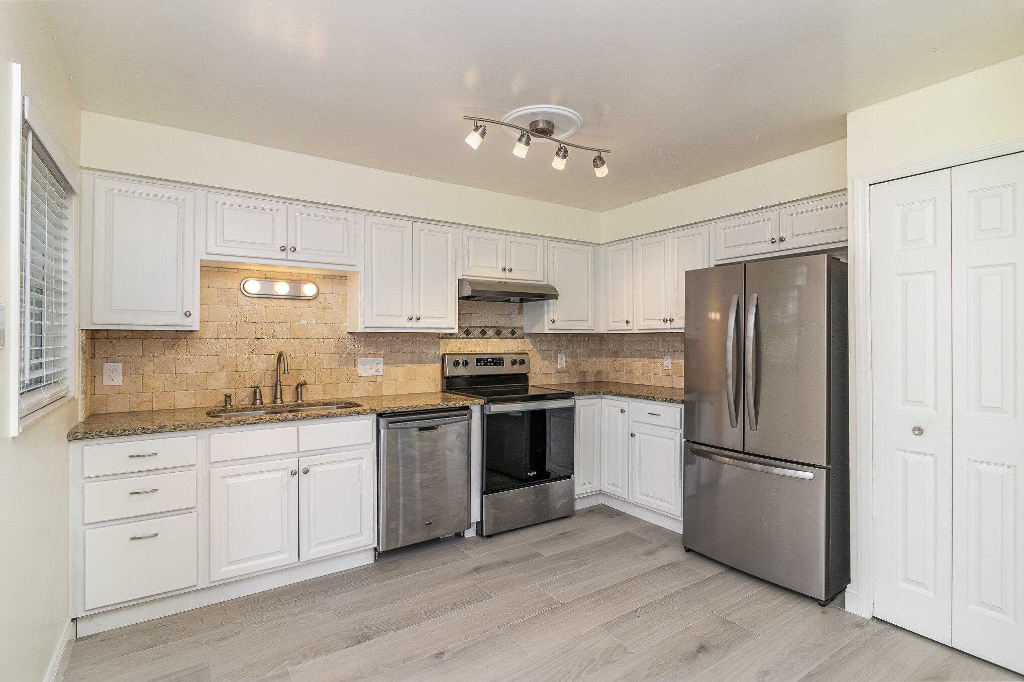 446 Timberlake Drive Melbourne, FL 32940 - Photo 4 of 20 a kitchen with white cabinets and stainless steel appliances