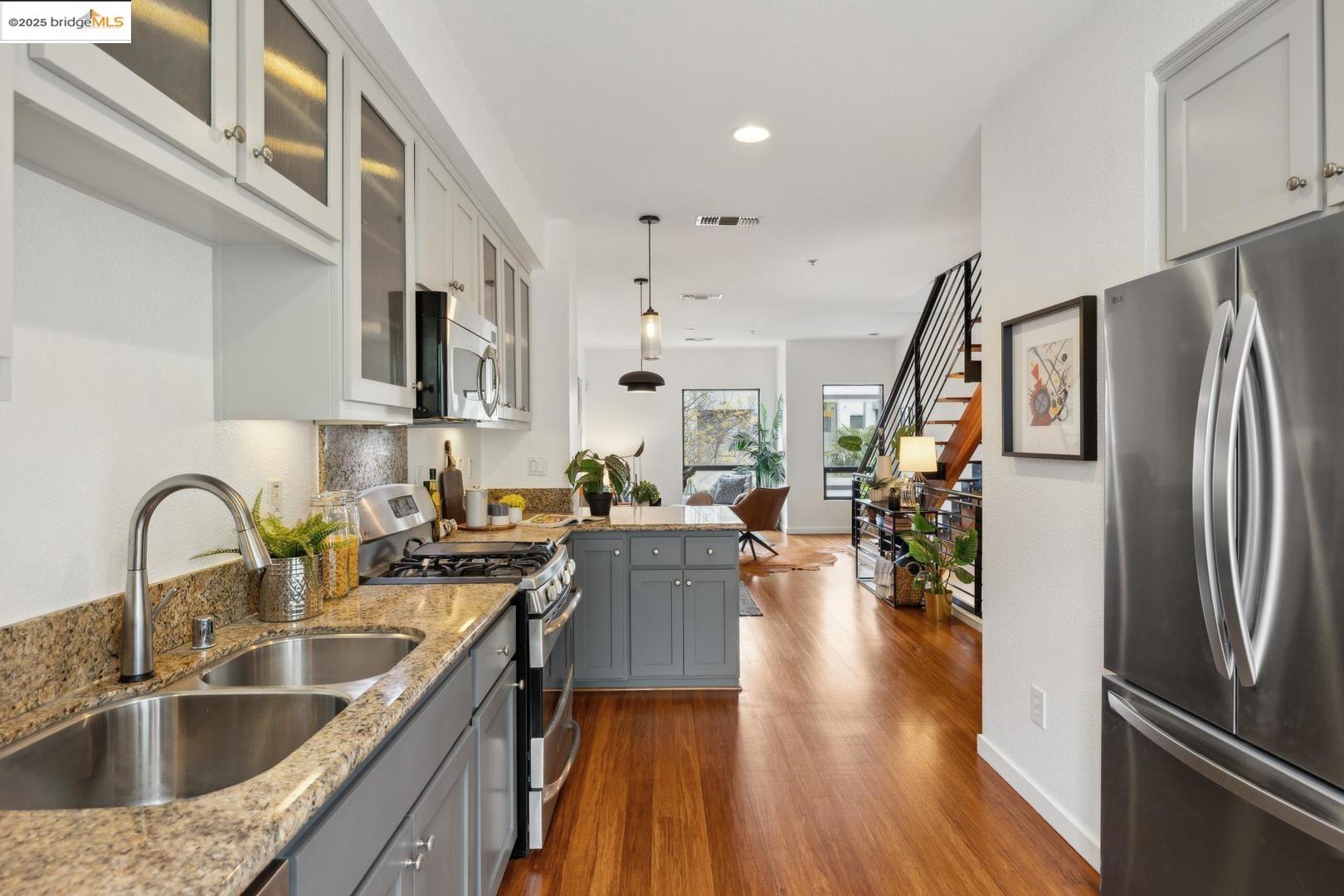 1769 14th Street Oakland, CA 94607 - Photo 1 of 27 a kitchen with stainless steel appliances granite countertop a refrigerator a sink a stove and white cabinets with wooden floor