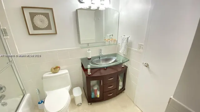 a bathroom with a granite countertop toilet sink and mirror