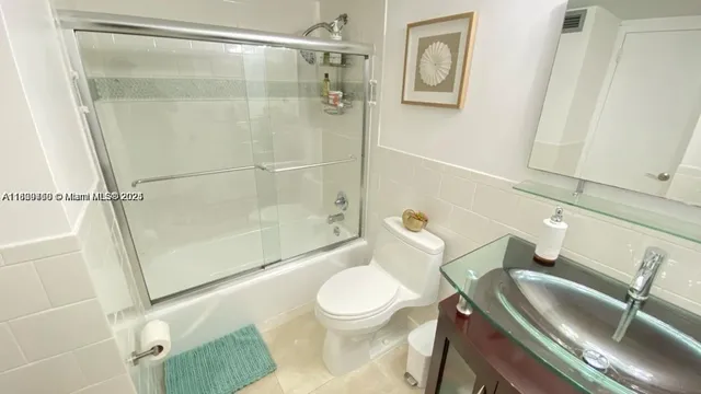 a white toilet sitting next to a bath tub