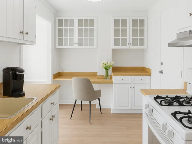 a kitchen with stainless steel appliances granite countertop a stove and a white cabinets