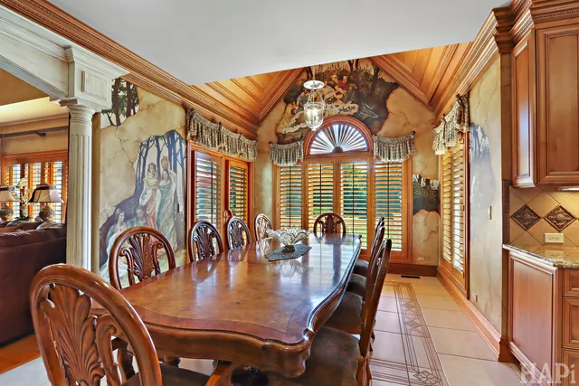 a spacious bedroom with a bed table closet and a chandelier