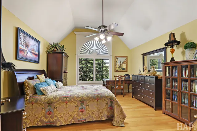 a view of a roof deck with table and chairs under an umbrella with barbeque grill and wooden floor