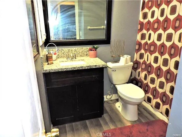 a bathroom with a granite countertop toilet and a sink
