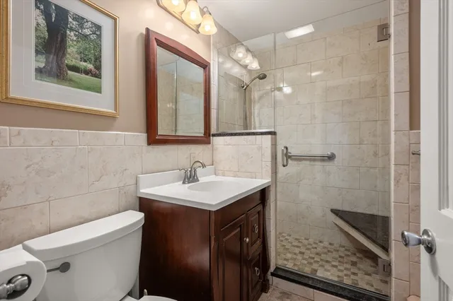 a bathroom with a sink a toilet a mirror and shower