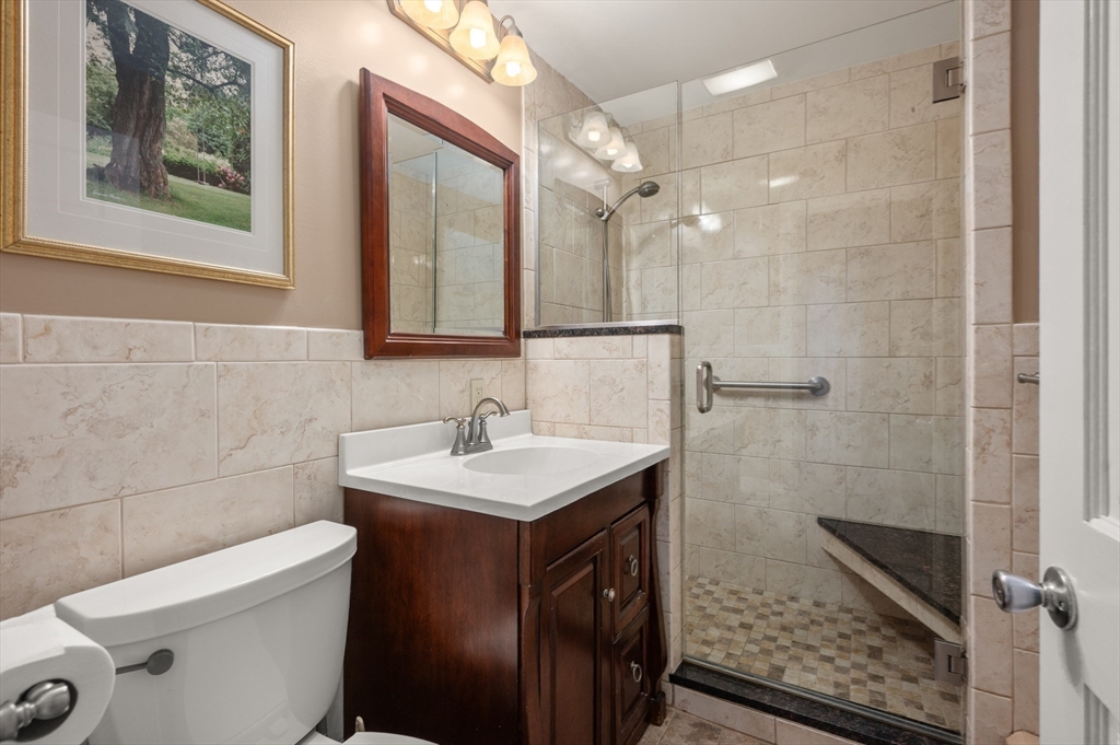76 Windsor Road, Unit 1 Medford, MA 02155 - Photo 13 of 32 a bathroom with a sink a toilet a mirror and shower