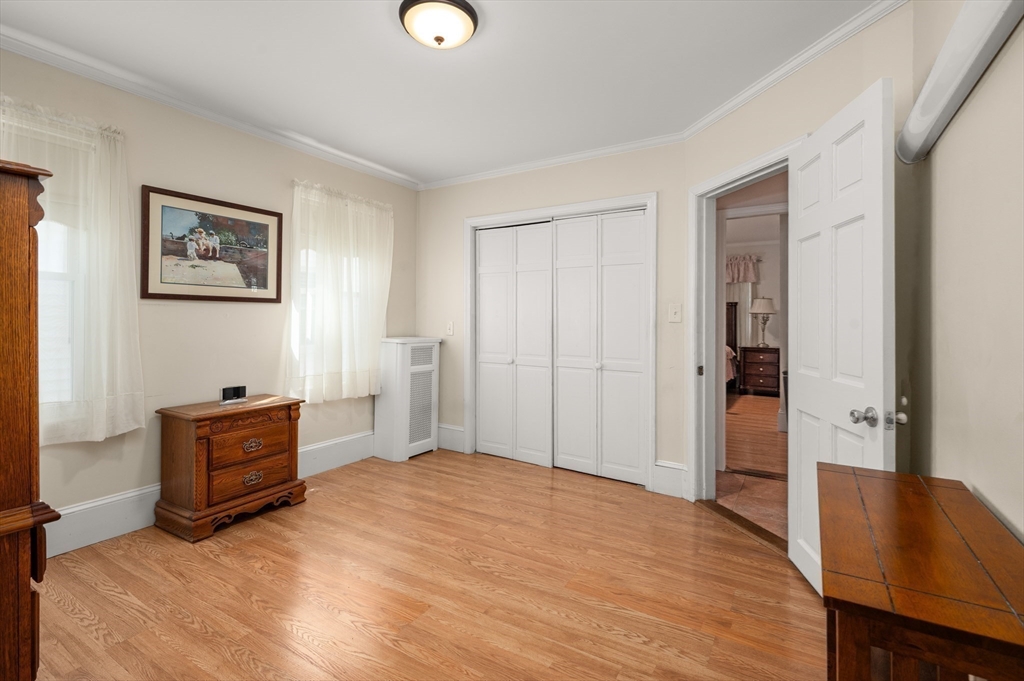 76 Windsor Road, Unit 1 Medford, MA 02155 - Photo 16 of 32 a bedroom with a bed and a dresser