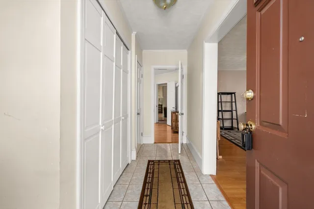 a view of a hallway with wooden floor and a bathroom