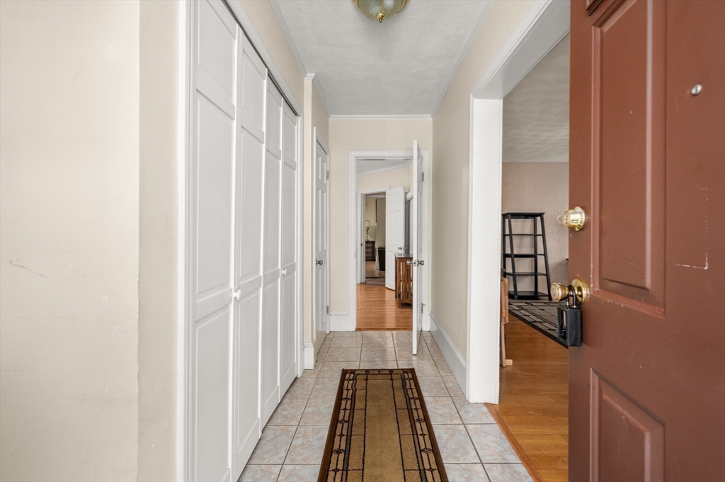 76 Windsor Road, Unit 1 Medford, MA 02155 - Photo 22 of 32 a view of a hallway with wooden floor and a bathroom