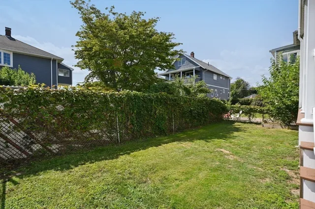 a backyard of a house with plants and large trees