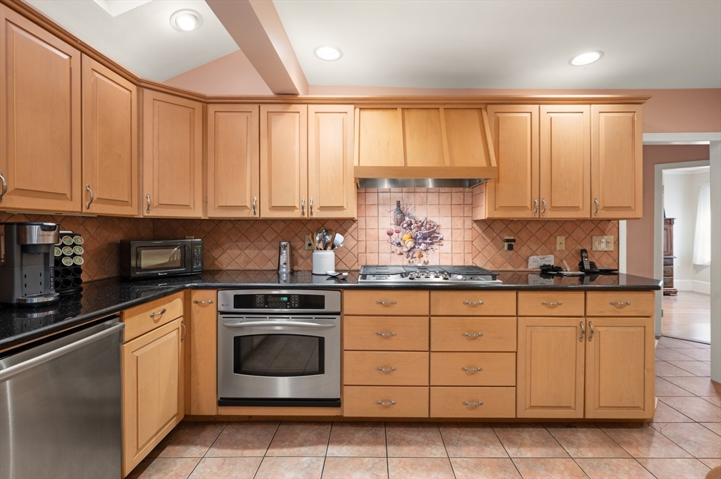 76 Windsor Road, Unit 1 Medford, MA 02155 - Photo 5 of 32 a kitchen with granite countertop white cabinets and white appliances