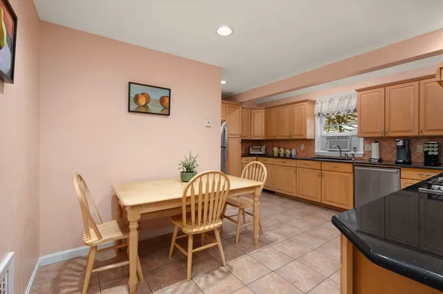 a kitchen with granite countertop chairs and white appliances