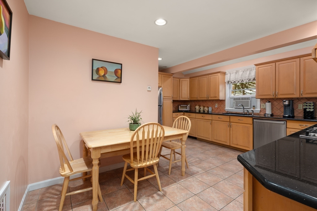 76 Windsor Road, Unit 1 Medford, MA 02155 - Photo 7 of 32 a kitchen with granite countertop chairs and white appliances