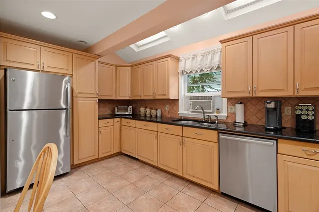 a kitchen with granite countertop a refrigerator and a sink