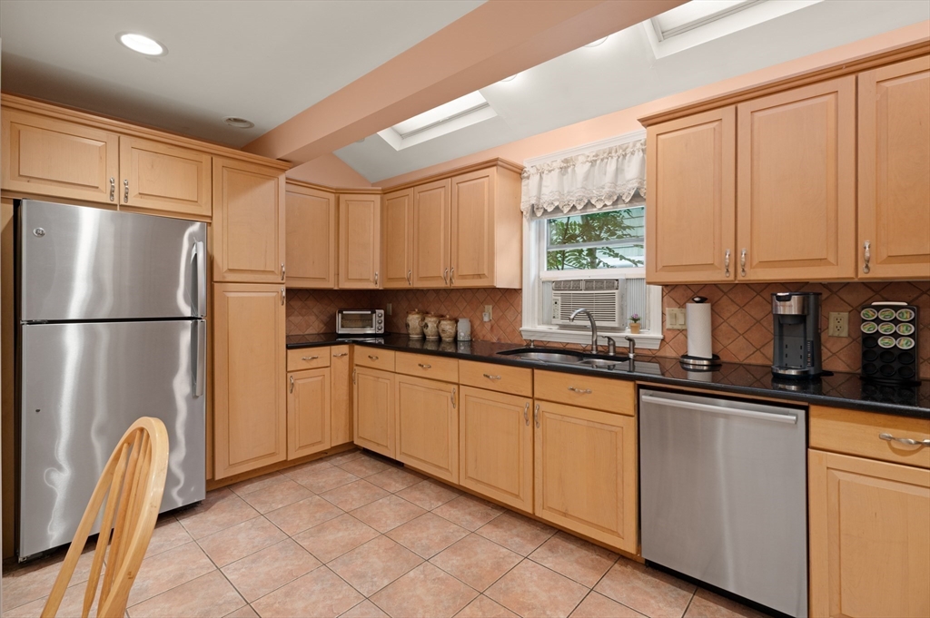 76 Windsor Road, Unit 1 Medford, MA 02155 - Photo 8 of 32 a kitchen with granite countertop a refrigerator and a sink