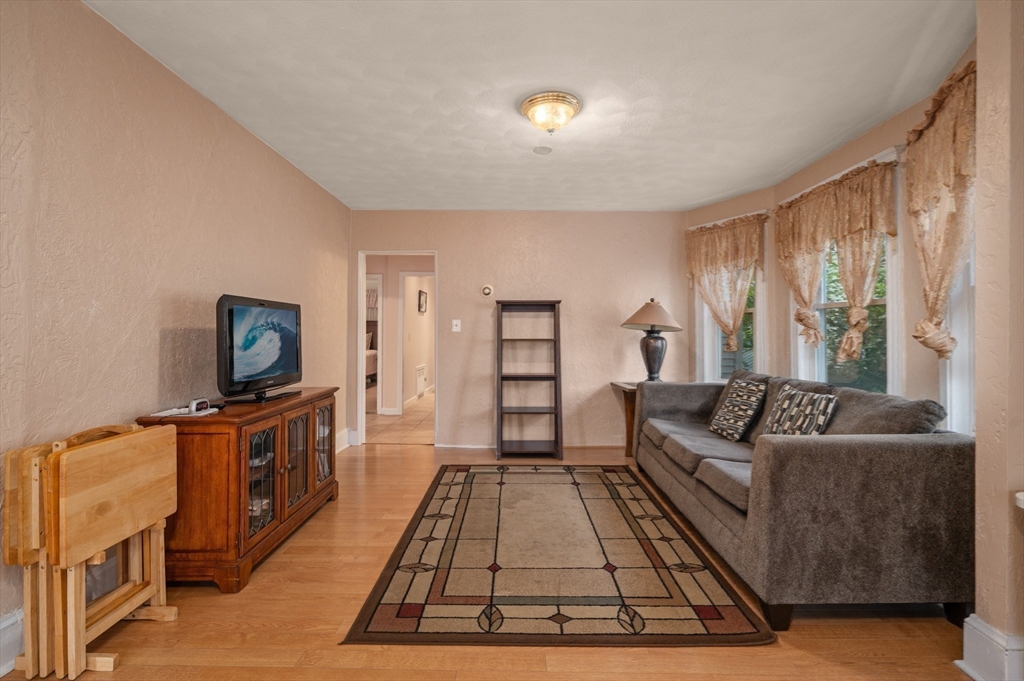 76 Windsor Road, Unit 1 Medford, MA 02155 - Photo 10 of 32 a living room with furniture a flat screen tv and a fireplace