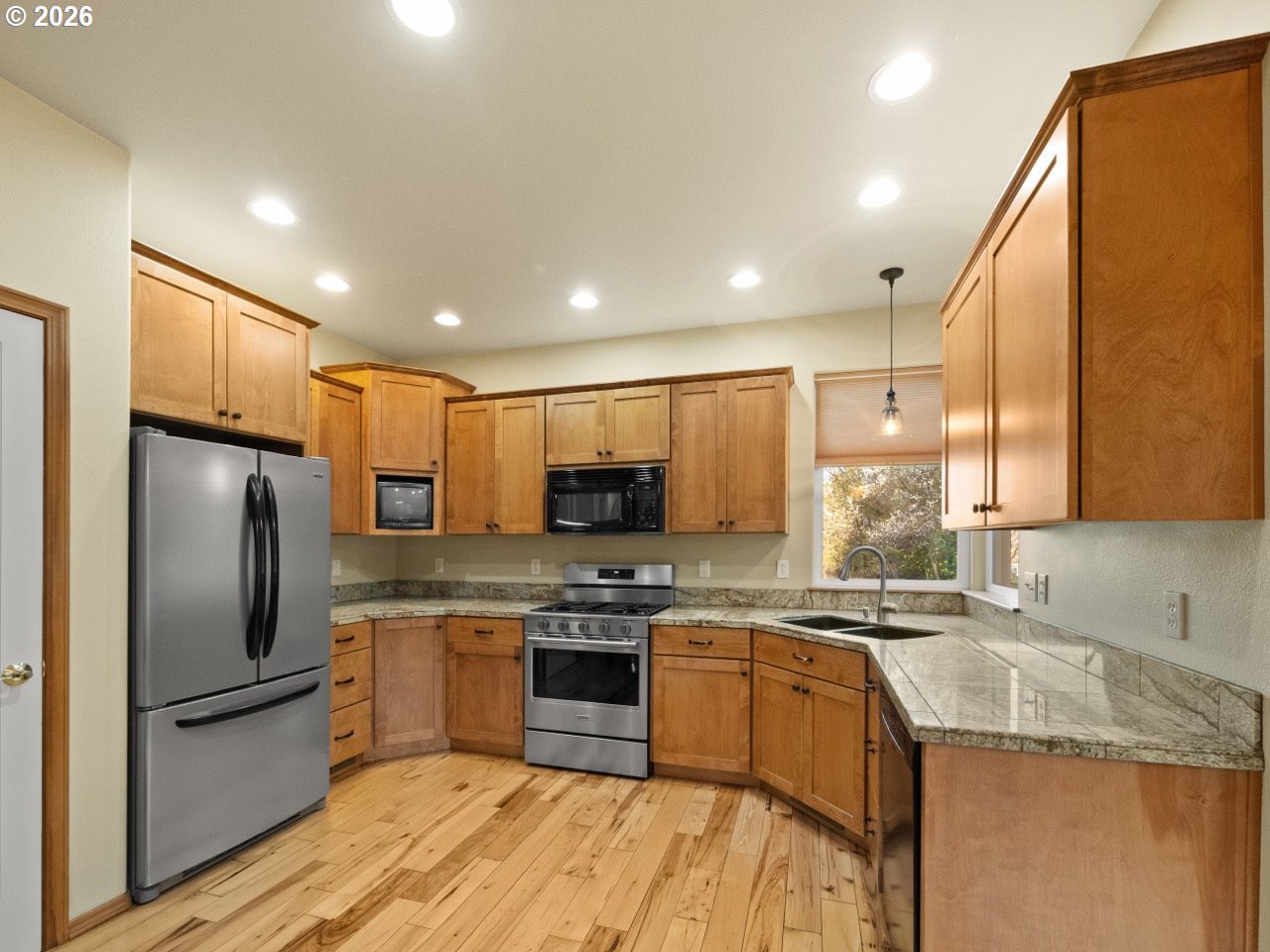 1101 B Avenue La Grande, OR 97850 - Photo 9 of 35 a kitchen with stainless steel appliances granite countertop a stove a sink a refrigerator and white cabinets with wooden floor