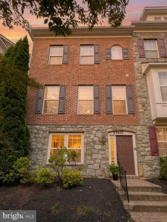 a front view of a multi story residential apartment building with yard and parking space