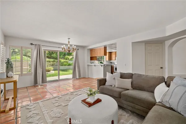 a living room with furniture and a large window with garden view