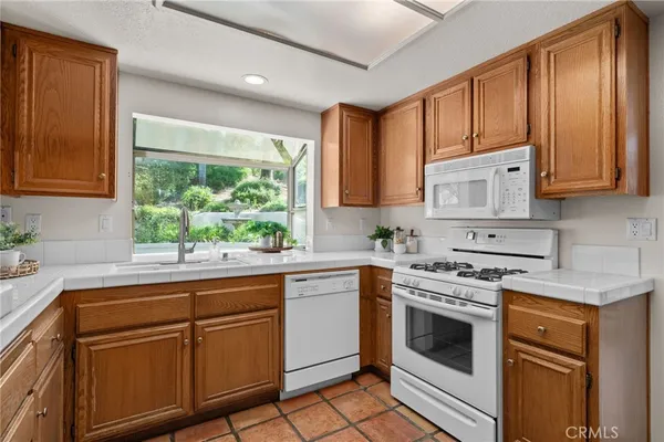 a kitchen with white cabinets white stainless steel appliances and sink
